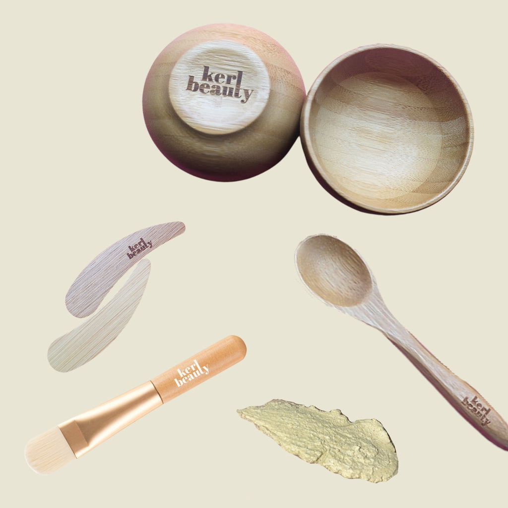 Face Mask Kit (gift set) for DIY at-home spa facial. Showing a bamboo bowl, spoon and spatula (with Kerl Beauty engraved), mini face brush, and clay face mask smear.